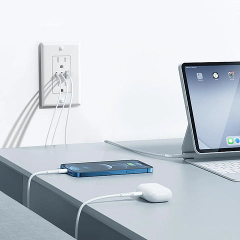 Haul This Smooth Usb Wall Outlet With Two Type C And One Type A Ports For Reliable Six Amp Fast Charging To Keep Every Gadget Pumped Full Of Juice No Fuss Ever Just Install And Go In Classic White near a desk with cables connected to a phone and tablet.