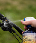 Saver Bundle Wet Bike Chain Lube And Bike Cleaner Set being sprayed onto bike handlebars for cleaning and maintenance.