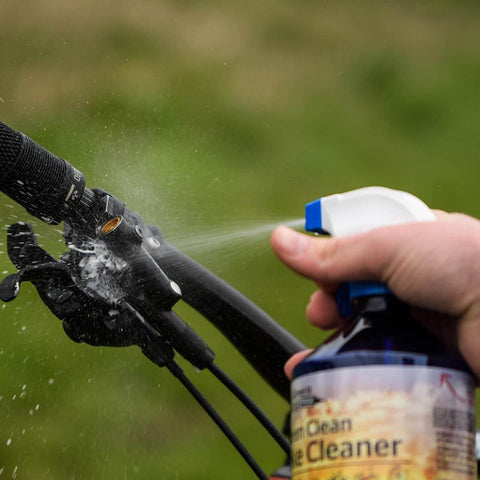 Saver Bundle Wet Bike Chain Lube And Bike Cleaner Set being sprayed onto bike handlebars for cleaning and maintenance.