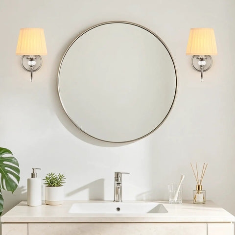 1-Light Brushed Nickel Vanity Light with Beige Fabric, Modern Wall Sconce beside a round mirror and vanity sink.