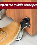 Person's foot on the pedal of Heavy Duty Retractable Workbench Caster Wheels 2 Piece Set for easy equipment mobility.