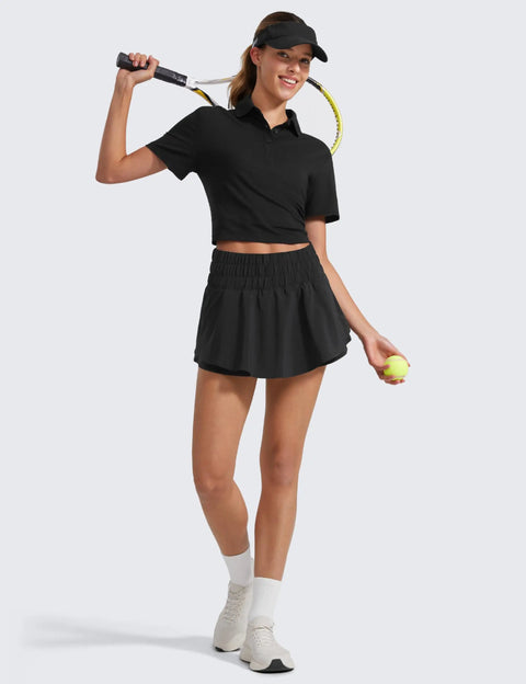 Woman wearing black Ruffle Skirt Overlay Workout Shorts For Women With High Rise Waist Built In Mesh Liner Quick Dry Soft Fabric, holding tennis equipment.