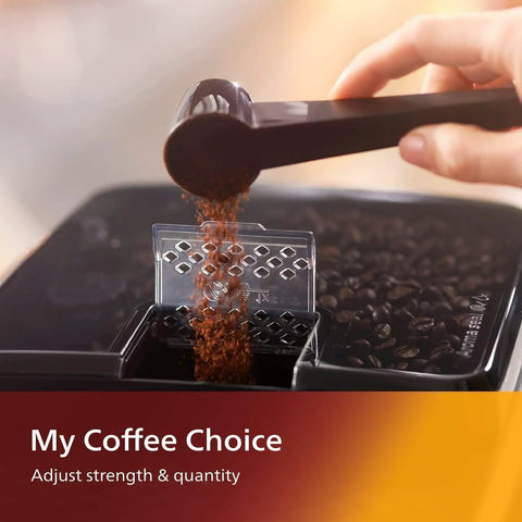 Pouring ground coffee into the hopper of Straight Fire Fully Automatic Espresso Machine With LatteGo Milk Frother.