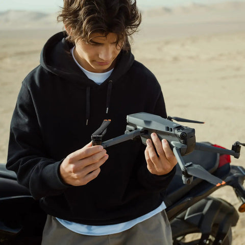 Person holding Mavic 3 Cine Premium Drone Kit with Hasselblad 4/3 CMOS Camera in a desert setting
