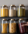 Top Notch Slick Large Glass Kitchen Jars Set Of Four Aluminum Lids with pasta and beans on a shelf, perfect for countertop organization.