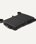 Amazon Basics Panini Press And Electric Indoor Grill With Adjustable Temp Settings Non Stick Ceramic Plates Black in open position.