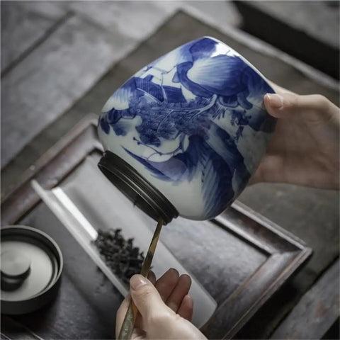 Solid Ceramic Tea Canister For Loose Leaf Storage being held with a spoon, showcasing its retro minimalist design and moisture proof lid.