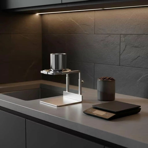 Minimalist Silver Finish Pour Over Coffee Dripper With Solid Metal Base on kitchen counter with coffee beans and scale.