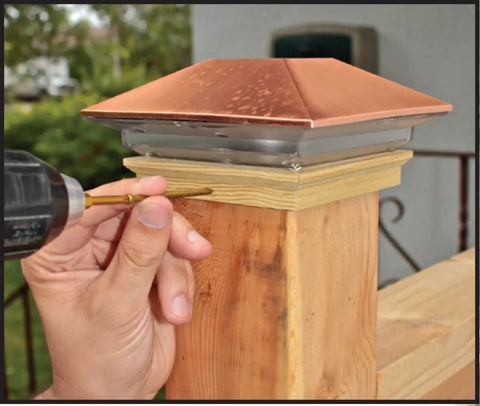 Hand using Eight By Two And A Half Inch Fasteners For Trim And Cabinetry With Gold Finish Trim Head And Star Drive on wood post
