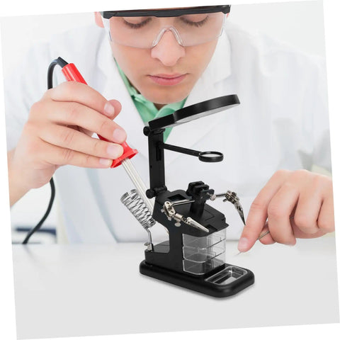 Person using a rechargeable USB welding clip light with magnifier for soldering on workbench, bright LED, adjustable beam.