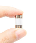 Close-up of a hand holding 10 Pack F5AL Fast Blow Glass Fuses 5A 125V 5x20mm showing clear glass tubes and metal ends.