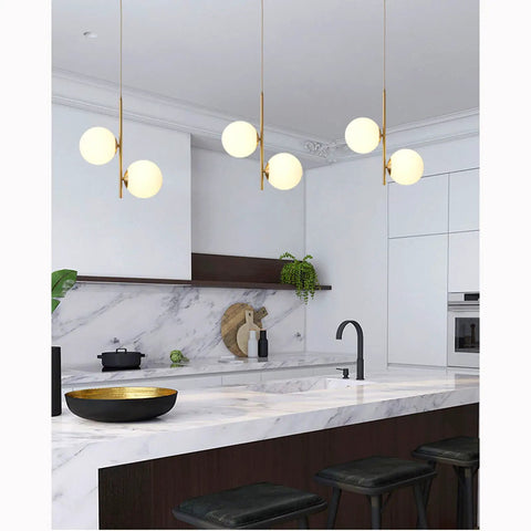 Dope 2 Light Globe Pendant Lighting With White Glass Shades And Brass Accents in modern kitchen setting