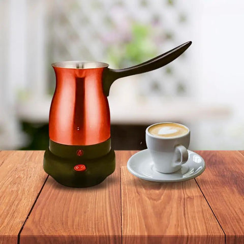 Electric Turkish Coffee Pot Kettle With Cool Touch Handle And Stainless Steel Body Travel Size 0.3L Red next to a coffee cup.