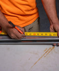 Worker using Ultra Fine Tip Permanent Markers Two Pack For Worksite Use With Professional Grade Ink on a metal surface with tape measure
