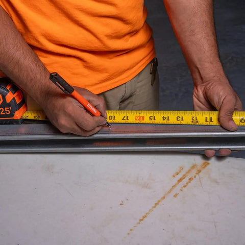 Worker using Ultra Fine Tip Permanent Markers Two Pack For Worksite Use With Professional Grade Ink on a metal surface with tape measure