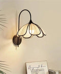 Nordic Floral Petal Wall Sconce Fabric Shade Wall Light,Warmth with soft white shade and black metal design on wall.