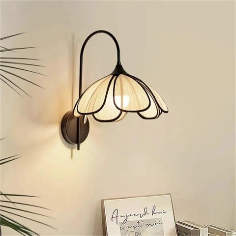 Nordic Floral Petal Wall Sconce Fabric Shade Wall Light,Warmth with soft white shade and black metal design on wall.