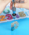 Using Killer Precision Steel Pin Vise Hand Drill with mini drill bit on resin letter D for crafting and DIY projects.