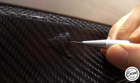 Slick Retractable Awl And Air Release Needle No Fuss Carbon Steel Scribe For Vinyl Weeding Cricut Crafting, detailing a bubble on vinyl.