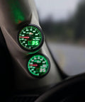 MaxTow 100 PSI oil pressure gauge kit with black face and green LED dial installed on a truck dashboard (2-1/16 in / 52 mm)