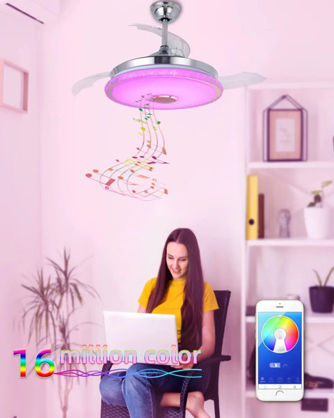 Retractable 42 Inch Ceiling Fan With Light And Bluetooth Speaker illuminating room with pink LED, woman using laptop below