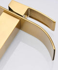 Close-up view of a gold bathroom faucet with curved design and textured handle