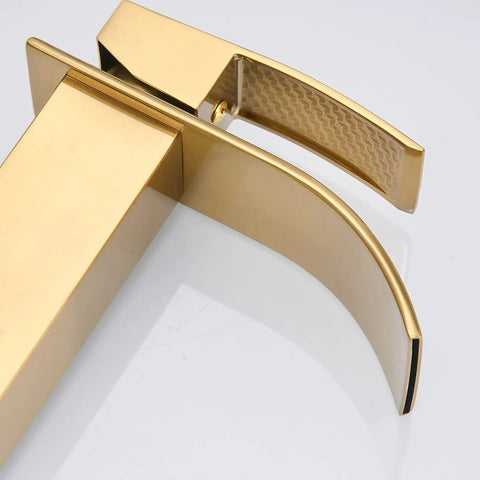 Close-up view of a gold bathroom faucet with curved design and textured handle