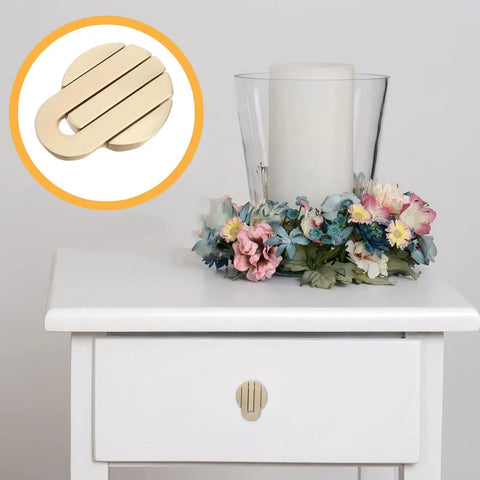 Concealed Round Cabinet Knobs In Matte Brass Single Hole Drawer Pulls installed on white dresser with floral decor