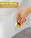 Two Piece Gold Ceramic Bird Toilet Bolt Covers Snazz Up Your Bathroom By Hiding Ugly Base Bolts With Cute Screw Caps That Bring Fresh Decor Vibes And Make Easy Installation A Breeze For Any Home Setup, shown in hand for easy installation.