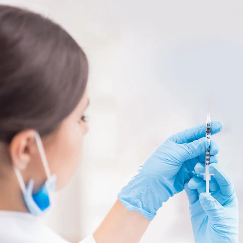 1 Ml Syringe With 31G Five Sixteenth Inch Needle Pack Of 30 Individually Wrapped Lab Tools For Quick Readouts And A Smooth Plunger Clear Scale And Airtight Inner Wall Perfect For Lab Work Medical Demos Or At Home Experiments. gloved hand holding 1 mL syringe with scale