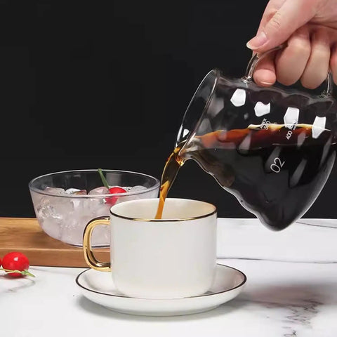 Pouring coffee from a glass carafe into a white cup on a saucer, with ice bowl in background, Smooth Sippin Cold Brew Drip Coffee Maker With Stainless Filter And Adjustable Flow Yields Barista Style Drinks Via Glass Carafe On Acrylic Stand Makes 3 To 6 Cups Major Upgrade For Coffee Crew Seeking Dope Routines.