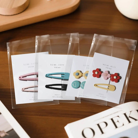 Self Sealing Clear 6 By 9 Inch Cellophane Bags Pack Of 200 For Cookies Snacks Bakery Gifts Envelopes Small Parts With Resealable Adhesive And Scalloped Edges For Easy Grab-And-Go Packaging. Clear 6x9 cellophane bags holding hair clips and cards