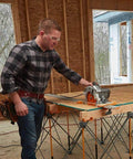 Side view of clamp-edge saw guide with circular saw on orange 100-inch track in a woodshop.