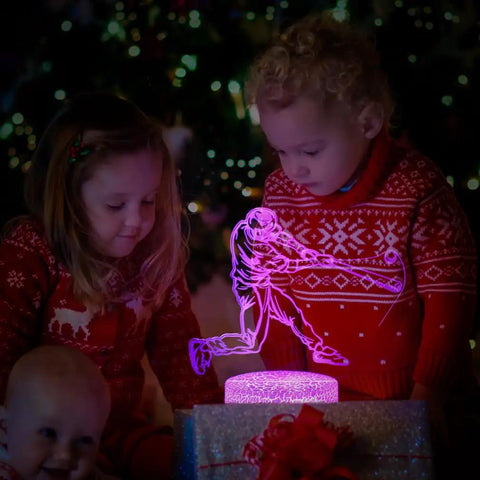 Children in sweaters admire Baseball Man 3D Lamp Night Light With Remote Control And Touch Sensor, glowing with purple light.