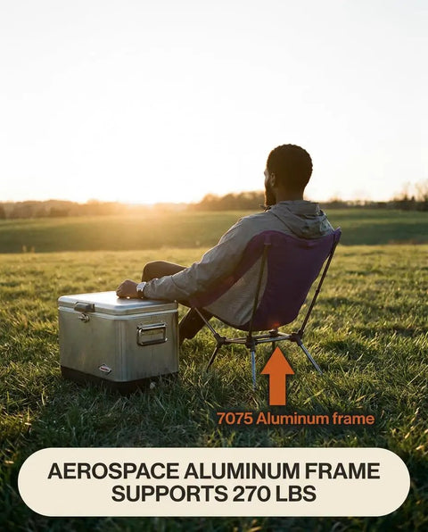 Person sitting on Capy OG Low Back Camping Chair With Tri Lock Stability Ultra Lightweight Portable Camp Chair in a field
