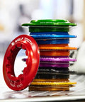 Stack of colorful rotor lockrings including red, green, and blue, showcasing Centerlock Rotor Lockring with Internal Spline Black 7075-T6 Aluminum Ultra Lightweight 10.5g Fits 12mm Through Axle Or Quick Release Keeps Your Disc Setup Secure On The Go.