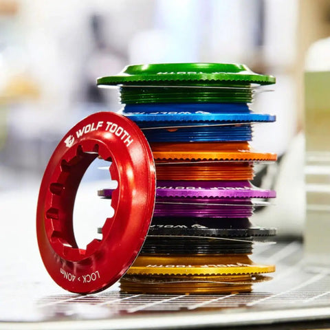 Stack of colorful rotor lockrings including red, green, and blue, showcasing Centerlock Rotor Lockring with Internal Spline Black 7075-T6 Aluminum Ultra Lightweight 10.5g Fits 12mm Through Axle Or Quick Release Keeps Your Disc Setup Secure On The Go.