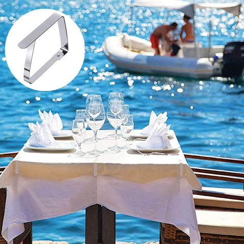 Heavy Duty Outdoor Tablecloth Clips Set Flexible Stainless Steel Picnic Table Clip Holders For Tables Up To Two Inches Thick Reusable 12 Pack Secure Indoor Or Outdoor Table Covers holding tablecloth by the sea.