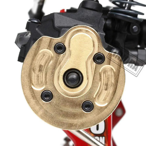 Close-up of brass portal steering knuckle for Axial SCX10 III Capra 1.9, showing detailed finish and installation on RC crawler.