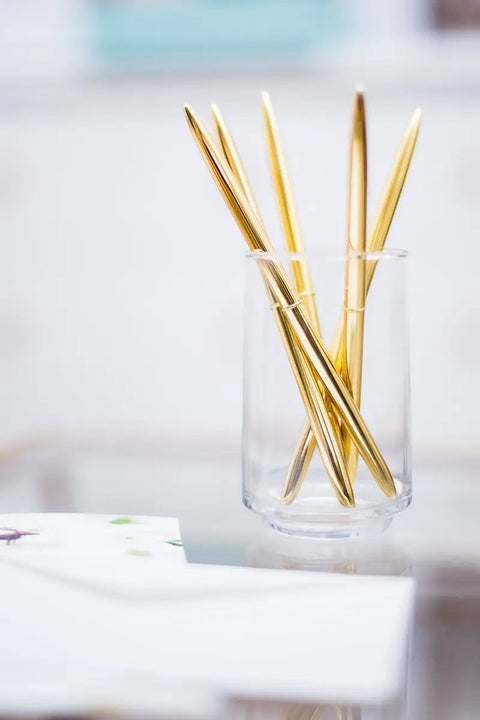 Premium Ballpoint Pen Set Of 6 In Glossy White Gift Box With Gold And Black Ink For Women And Men displayed in a glass holder