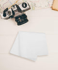Straight Up Spotless With This Reusable Eyeglass Cleaning Cloth Nano Dust Free Microfiber Wiper For Glasses Computer Screens Laptops And Optical Gear on a wooden table with a film camera.