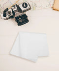 Smooth Operator Microfiber Cleaning Cloth Removes Fingerprints And Leaves Absolutely No Trace Behind Perfect For Eyeglasses Camera Lenses Computer Screens And Watches Delivers A Crisp Spotless Shine Daily With Its Durable Lint Free Fabric on a table near a vintage camera.