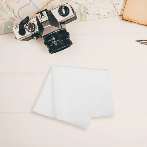 Top Shelf Reusable White Microfiber Cleaning Cloth For Eyeglasses And Camera Lenses Ultrafine Cleanroom Grade placed beside a camera.
