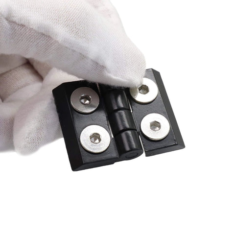 Close-up of black pivot hinge from 10 Series 1010 Hinge And Door Handle Kit For 1 By 1 Inch Aluminum Profiles, held by gloved hand