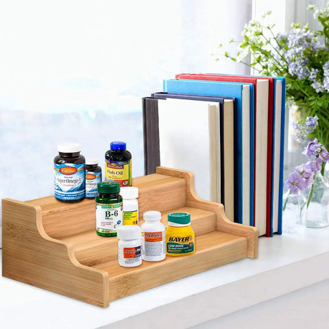 Expandable 3 Tier Bamboo Spice Rack And Kitchen Cabinet Organizer fits standard jars horizontally displaying vitamins and books.