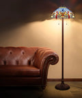 Blue Tiffany Style Floor Lamp 64 Inch Tall With Stained Glass Shade Durable Resin And Aluminum Base Includes Two 2700K E26 LED Bulbs Retro Pull Chain Gift Ready To Elevate Your Living Room Or Bedroom Vibe next to a brown leather sofa
