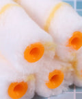30 PCS Mini Paint Roller Sleeve Refills, High Density Foam Rollers For Wall Painting, close-up on round foam sleeves with orange ends.