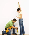 Man and woman using Four Pack 16ft Tape Measures Retractable With Auto Lock Dual Readouts Imperial And Metric Inches And Centimeters Rugged ABS Shell For Home Workshop Garage Car And Toolbox