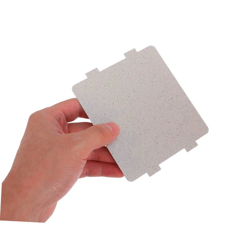 Person holding a microwave waveguide cover mica sheet replacement for ovens with high heat resistance and insulation board.