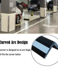 Heavy Duty Reflective Garage Wall Guard Plus Slick Rubber Corner Protector For Car Door Bumper Shield With High Visibility Night Safety Strip Tough As Nails Warehouse Parking Lot Anti Collision Bumper Guard Black in curved design mounted in garage.